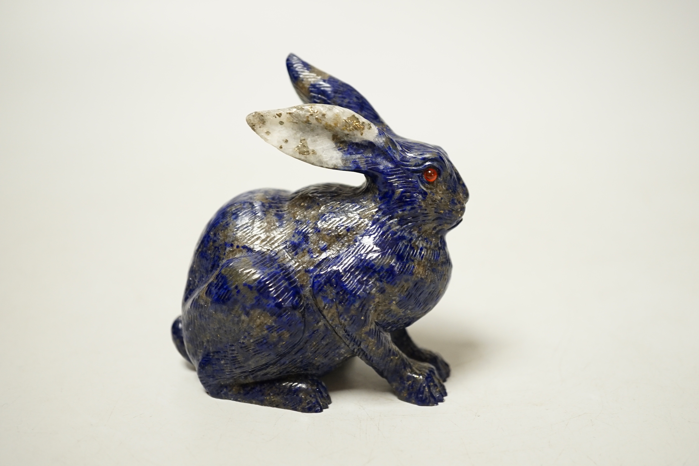 A Chinese lapis lazuli model of a hare, with glass inset eyes, 8.4cm high